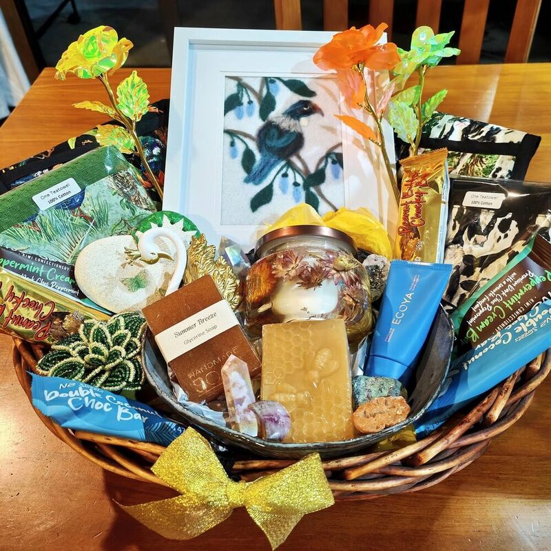 A wicker thank-you hamper of New Zealand-made soap, chocolate and a candle left on a table after a move